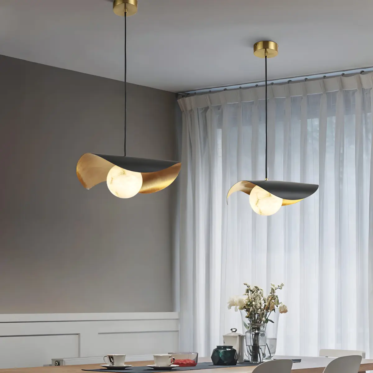 two ida lotus pendant light hanging in a dining room