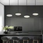 four luna cake pendant light hanging on kitchen island countertop