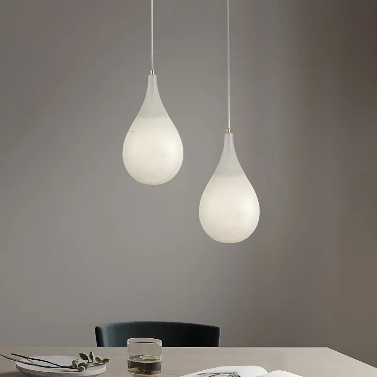double raindrop pendant light hanging above the table