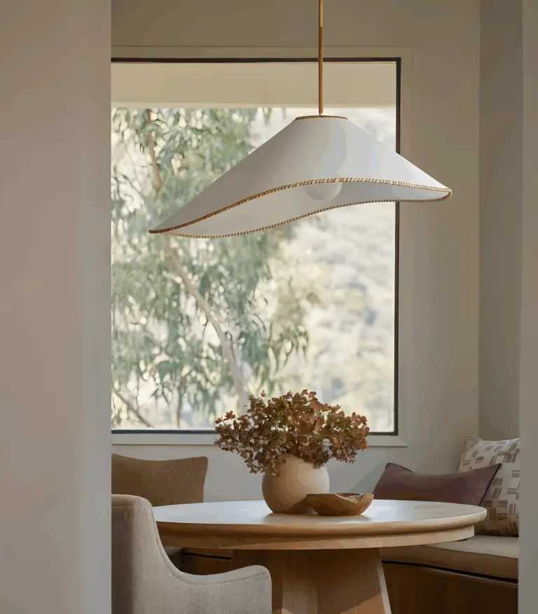 arroyo fabric pendant light hanging in dining room in front of a window