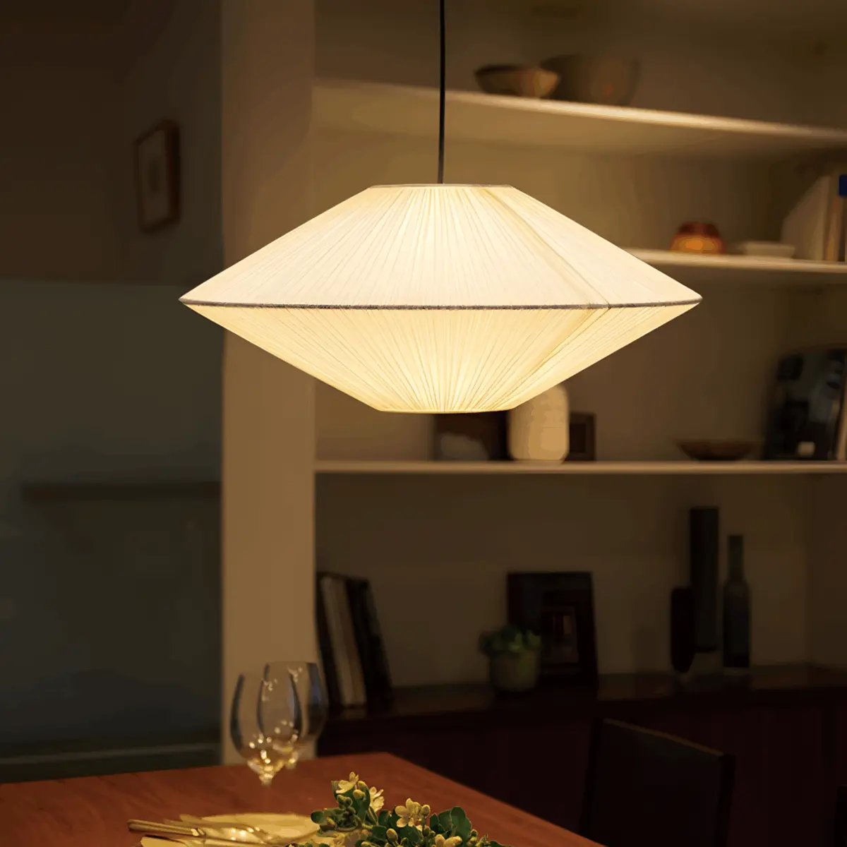 lighted brera fabric pleated pendant light hanging above table