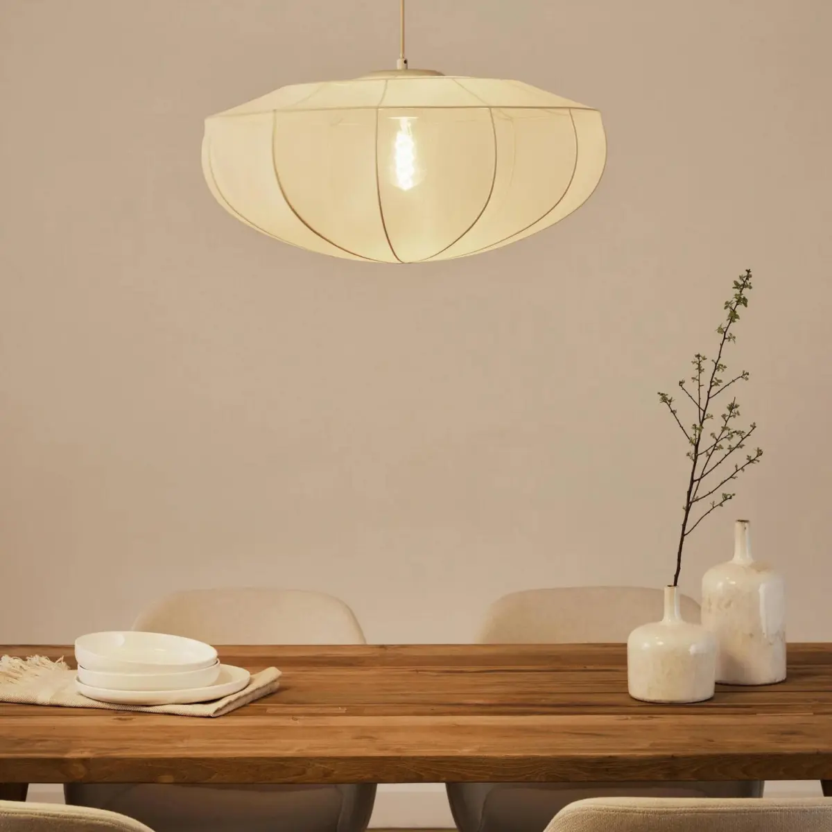 beige westwing beau fabric pendant light hanging above a wooden table